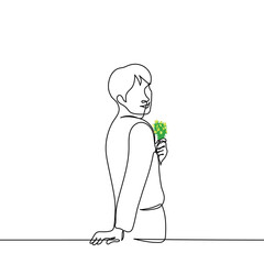 man stands smiling stands with his back holding a bouquet of meadow flowers one line drawing vector. concept man is playful, man loves flowers, man in love