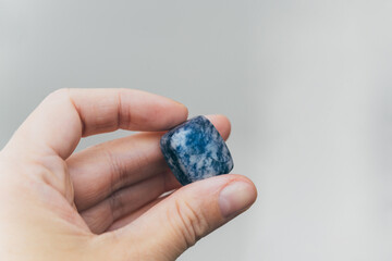 Hand holding blue quartz healing crystal