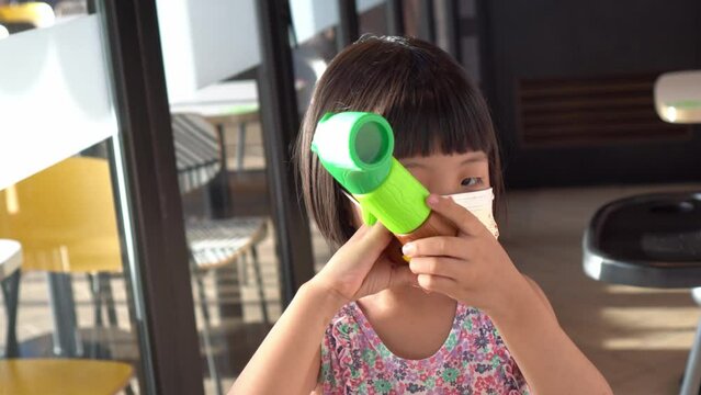Little girl wear face mask play periscope toy