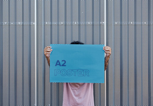 Anonymous Man Holding an Horizontal A2 Poster Mockup