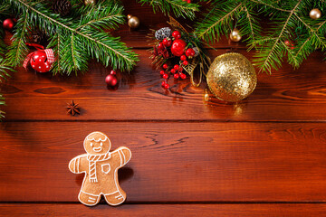 Christmas decor with real Christmas tree and gingerbread man on wooden background. Angle view....