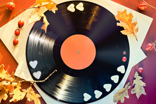 Vintage Vinyl Record In Paper Sleeves On Paper. Golden Yellow Oak Leaves On Orange, Magenta Paper Background With Autumn Decorations. Vintage Retro Music Collection Concept.