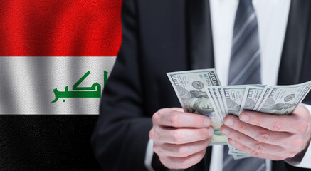 Hands holding dollar money on flag of Iraq
