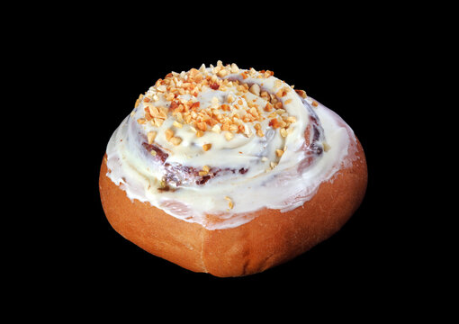 Cinnamon Bun With Nut Sprinkles Isolated On Black. Cinnabon Close-up. Homemade Fresh Cinnamon Roll. 