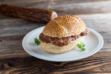 German salami or rote wurst on a sesame seed bun on wooden table