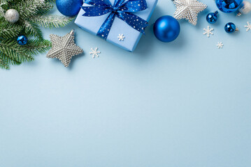 Christmas concept. Top view photo of giftbox with bow blue and white baubles silver star ornaments fir branches in snow and snowflake shaped confetti on isolated light blue background with blank space