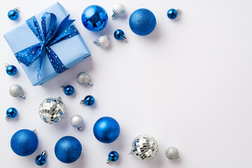 Christmas concept. Top view photo of blue white silver baubles disco balls and big giftbox with...