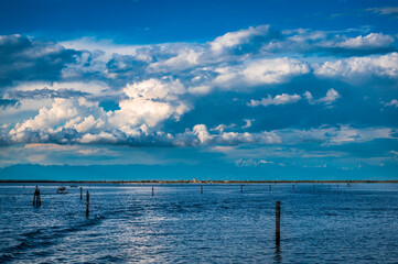 Obraz premium Towards the sunset. Marano lagoon late summer colors. Clouds and sun