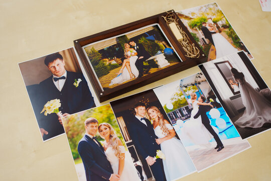 printed wedding photos and a wooden box with a flash drive. 