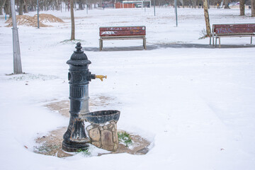 water fountain in the park with snow in winter