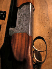 Slightly blurred close up of a decorated hunting rifle part, trigger and stock