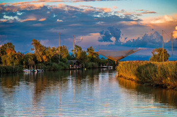 Towards the sunset. Marano lagoon late summer colors. Clouds and sun