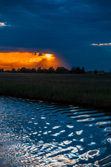 Towards the sunset. Marano lagoon late summer colors. Clouds and sun