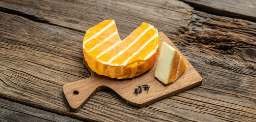 cream Round brie or camambert cheese on a wooden board. Rougette cheese on a wooden background, banner, menu, recipe place for text, top view