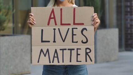 ALL LIVES MATTER on cardboard poster in hands of female protester activist. Stop Racism concept, No...