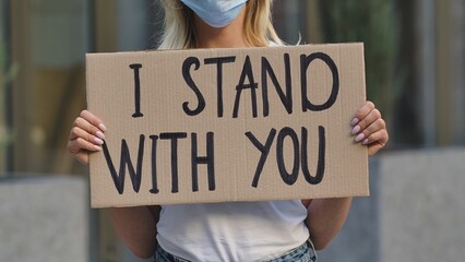I STAND WITH YOU on cardboard poster in hands of female protester activist. Stop Racism concept, No...