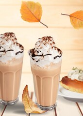 Tasty aroma latte in glass with leaves on the desk