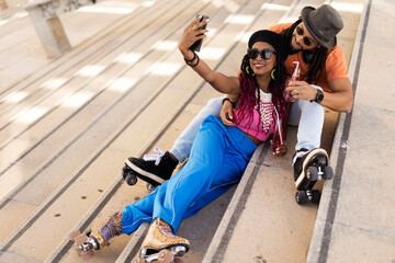 Obraz premium Cheerful couple roller skating outside. Fun sexy boyfriend and girlfriend taking selfie photo