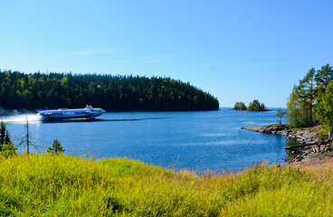 Hydrofoil motor ship leaves the bay of Valaam island. Journey on a sunny summer day © Aritel
