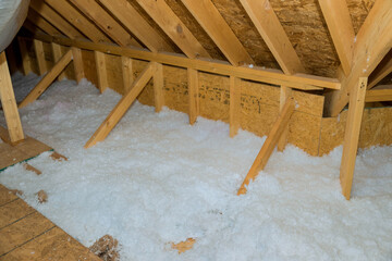 New homes attic insulation roof is being poured with eco wool insulation for purpose of insulating...