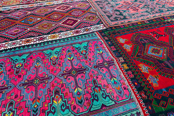 A street market with many colorful carpets lying on a cobbled street in the old town of Baku,...