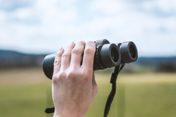 Obraz premium female hand holding a binoculars .