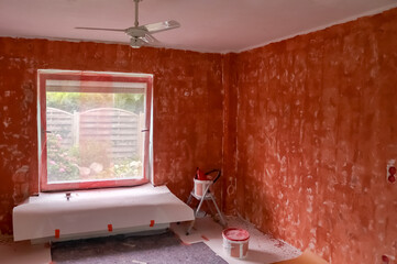 Renovation of a flat with red primer paint on the walls.