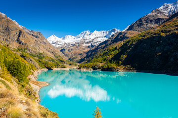 Fototapeta na wymiar Autumnal landscape of the Lake Place Moulin, an artificial glacial lake with turquoise water in the italian Alps, on the border with Switzerland