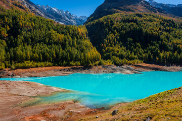 Autumnal landscape of the Lake Place Moulin, an artificial glacial lake with turquoise water in the italian Alps,  on the border with Switzerland