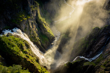 Verbazingwekkende zonnestralen die door de mist gaan die wordt gecreëerd door de Voringfossen-watervallen, Noorwegen