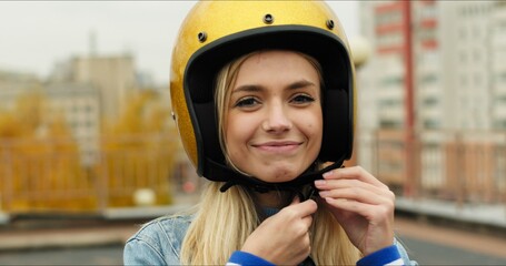 Close-up of Young Woman Wears Open Face Golden Motorcycle Helmet Before Riding a Bike