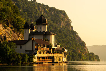Sunrise over Mraconia Monastery church from Romania at the shore of Danube river. Landmark...