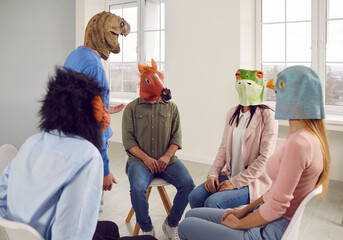Absurdity. Conversation of young people in rubber masks on their heads during support group...