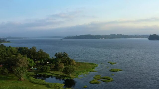 Beautiful rotating aerial drone shot of the stunning man-made Guarapiranga Reservoir in the south part of S&atilde;o Paulo, Brazil near Interlagos with beaches, marinas, and wildlife on a fall evening.
