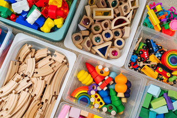 Toy Storage boxs in the children's room. Plastic containers with colorful wooden toys. Organizing...
