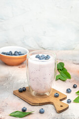 Blueberry jogurt, Tasty blueberry smoothie in glass on a light background, vertical image. place for text