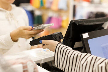 The buyer pays for purchases in the store, puts the smartphone to the terminal. the seller handed...
