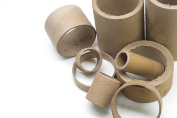 Cardboard cores of different sizes for winding various strips of material in the printing house. Industrial paper cores, tube and spools on a white background. Selective focus