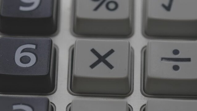 finger presses on the calculator sign multiply