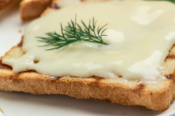 Sliced bread with cream cheese and butter for breakfast. melted cheese sandwich on light background. banner, menu, recipe place for text, top view