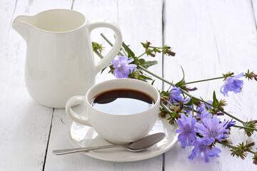 Fototapeta na wymiar Cup of coffee tea chicory drink with chicory flower on a white table