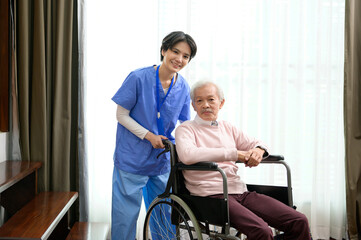 Asian nurse taking care of an elderly man sitting on wheelchair at  senior healthcare center.
