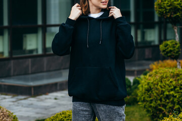 Young woman in glasses and black hoodie