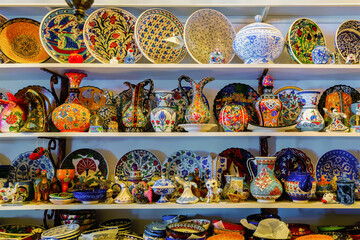 Shelves with classical traditional Turkish ceramics, handmade colorful dishes at the Selcuk Bazaar (near ancient Ephesus). Izmir, Turkey souvenirs. Selected focus, copy space
