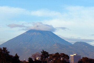 Agua Volcano at sunrise from Guatemala City, partially clear and blue sky, panoramic view in Latin America.