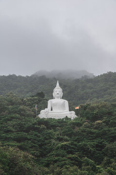 White buddha statue on the mountain in Wat Thep Phithak Punnaram temple Nakhon Ratchasima.