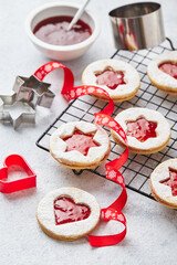 Classic Linzer Christmas Cookies with raspberry or strawberry jam on light background.