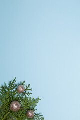 empty Christmas blue background with fir twigs and shiny silver tree balls, copy space
