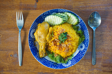 Biryani with chicken. Traditional Indian dish of rice and chicken marinated in spices and yoghurt.Top view. natural wooden background. Authentic Chicken Biryani served in a bowl or plate over colourfu