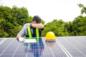 Asian male electrical engineer Supervise and supervise the installation of solar cell systems for customers on the factory roof. business concept solar energy or solar system. copy space. very tired